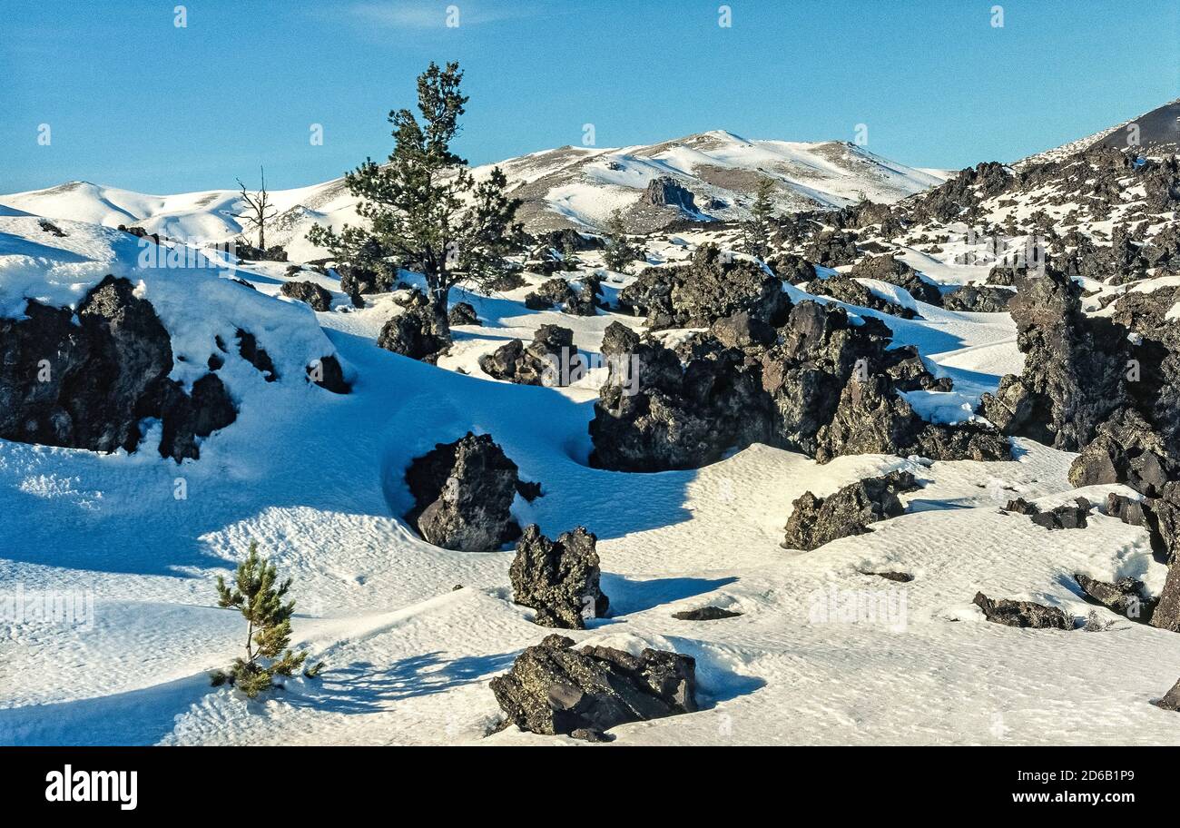 La neige couvre certaines des formations de lave noires qui sont parmi les caractéristiques du monument national Craters of the Moon et de préserver qui s'étend sur la plaine de la rivière Snake dans l'Idaho, aux États-Unis. Ce paysage particulier est le résultat de huit éruptions volcaniques majeures qui ont commencé il y a 15,000 ans et se sont poursuivies jusqu'à il y a seulement 2,000 ans. Les géologues prédisent que la région fera l'expérience d'une autre éruption dans les 100 à 900 prochaines années. Une route à boucle de 7 kilomètres (11 milles) permet aux visiteurs de visiter la réserve en voiture, et de nombreux sentiers encouragent d'autres explorations à pied. Banque D'Images