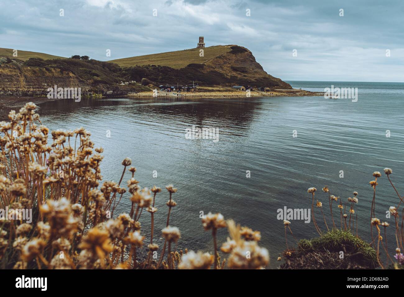 Vue sur la baie de Kimmeridge, Dorset Royaume-Uni, vue sur le paysage à travers les fleurs du rivage de mer, jour venteux au bord de la mer, Tour de pierre sur la colline avec spectaculaire Banque D'Images