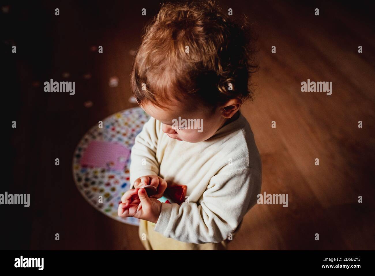 Bébé jouant avec un carton comprimé à la maison. Banque D'Images