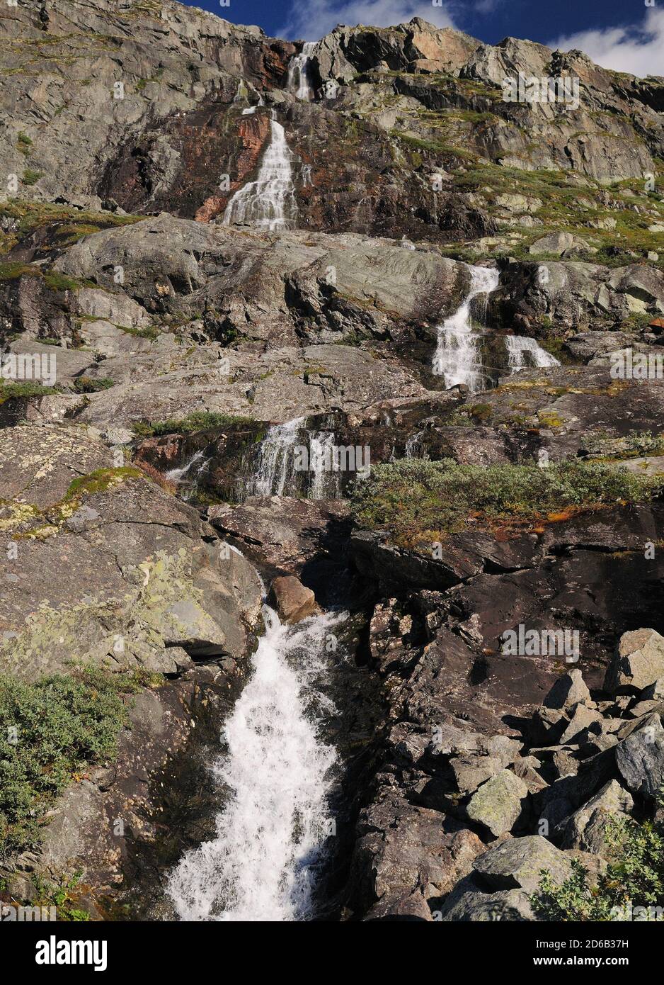 Cascade dans le paysage de Barren des champs de glace de Jotunheimen Parc national lors D'UNE Sunny journée d'été avec UN clair Ciel bleu et quelques nuages Banque D'Images