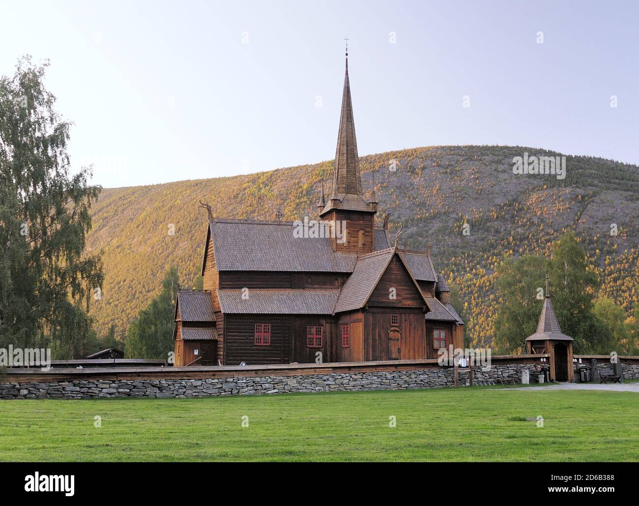 Belle église de la Stave en bois de LOM entourée par les montagnes et Arbres dans le parc national de Jotunheimen lors D'UNE journée ensoleillée d'été Avec UN ciel bleu clair Banque D'Images