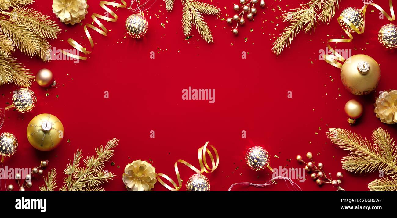 Boules de Noël dorées et branche de sapin sur fond rouge Banque D'Images