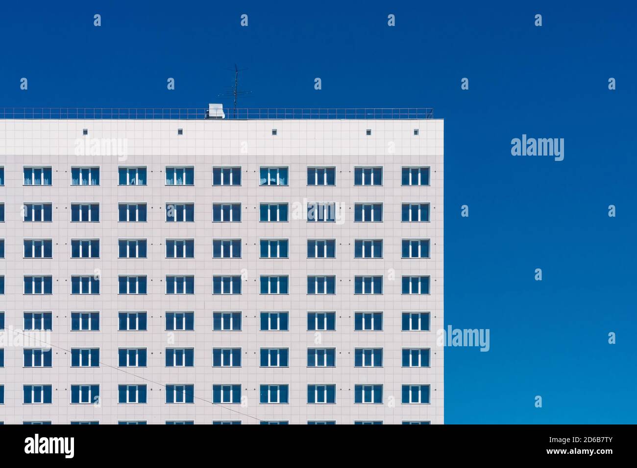 Arrière-plan géométrique avec beaucoup de lignes de fenêtre. Texture moderne du bâtiment. Construction de bureaux. Immeuble d'appartements de près. Beaucoup de fenêtres sur un mur énorme. E Banque D'Images