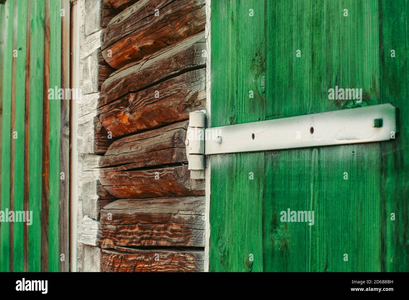 Charnières en fer blanc peint sur les portes en bois vert du hangar de près. Le fond texturé et détaillé avec des planches de bois de grange est peint de la douleur vert vif Banque D'Images