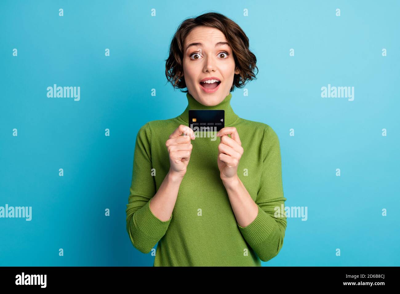Portrait de choqué surprise fille tenir carte de débit impressionné incroyable système de paiement bancaire facile style d'usure élégant pull-over tendance isolé bleu Banque D'Images