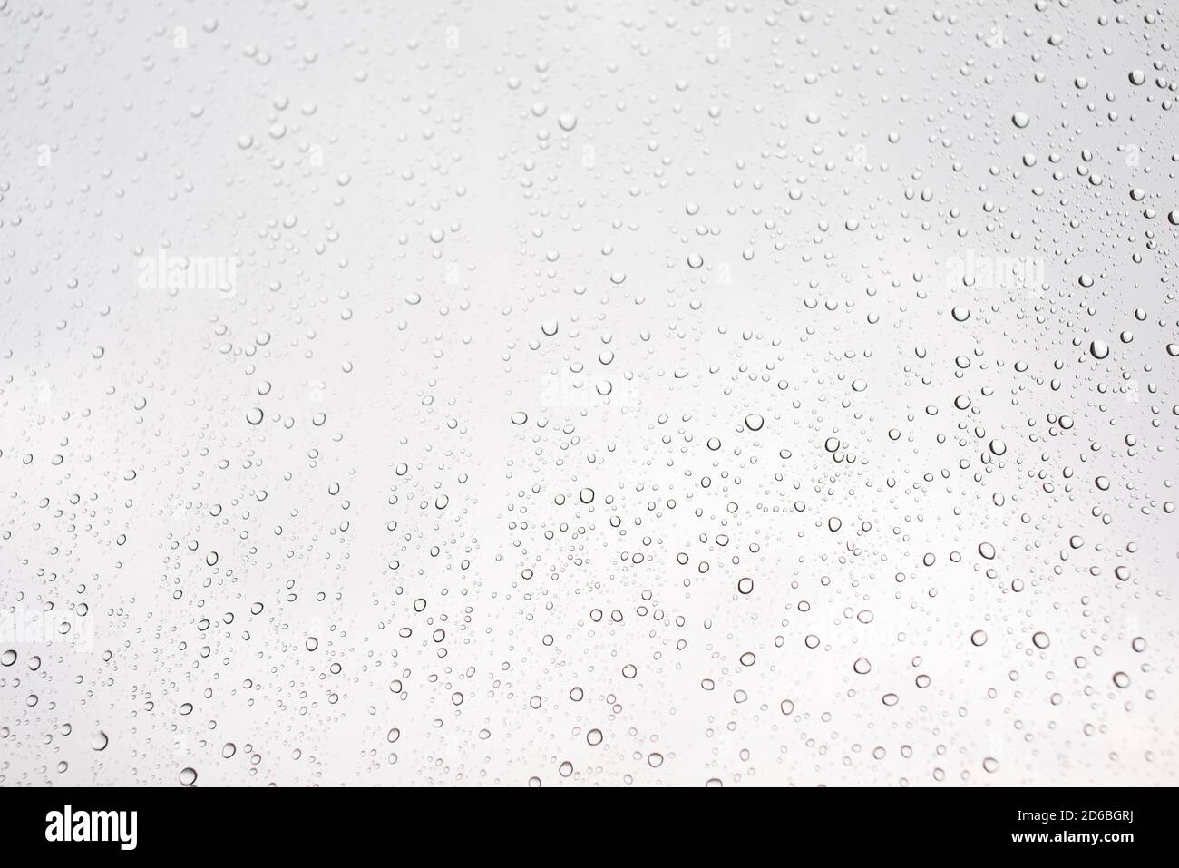 Goutte d'eau sur la fenêtre en verre avec ciel nuageux sur fond Banque D'Images