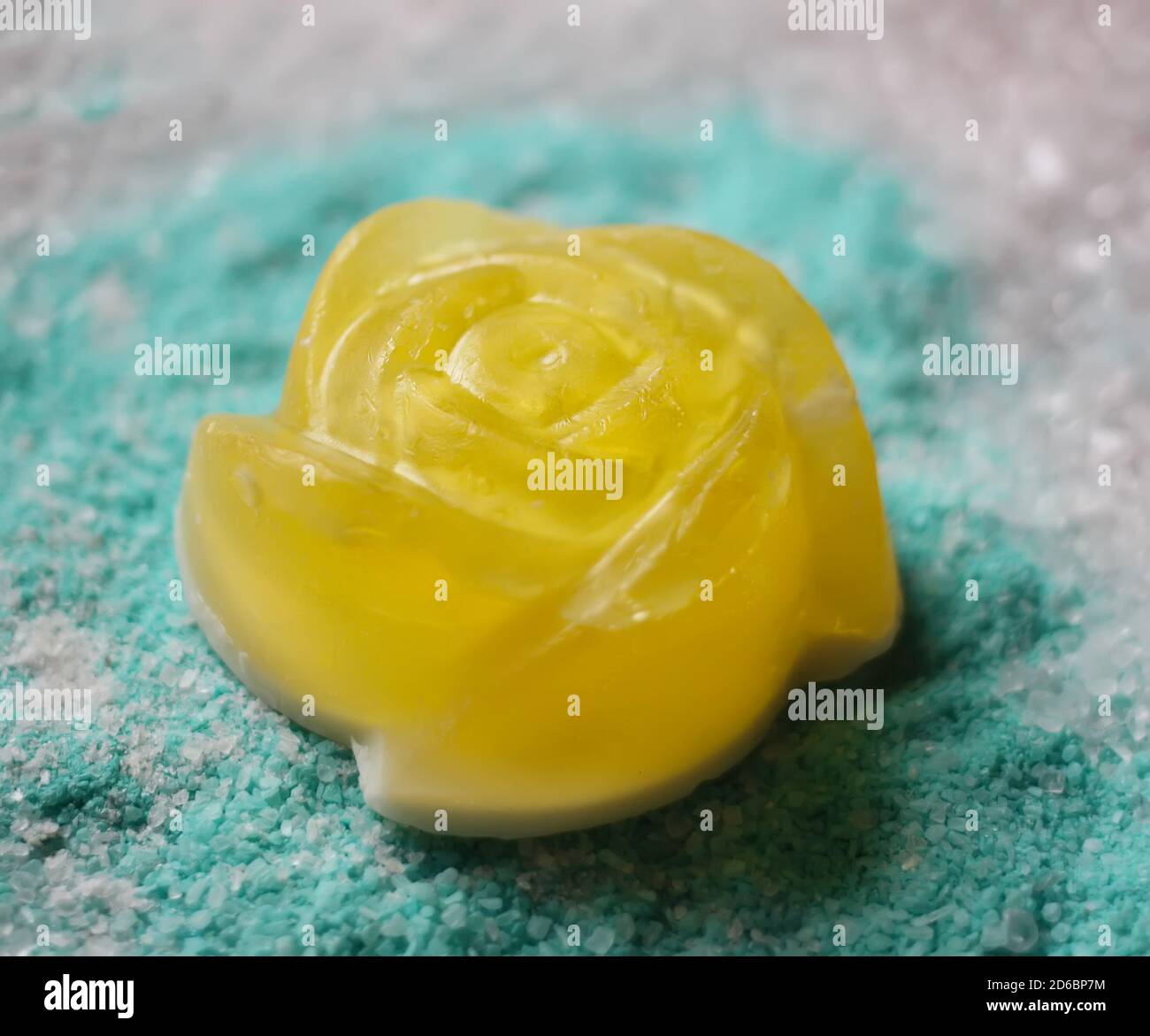 Petit savon jaune naturel fait à la main sous forme de rose sur fond parfumé de sel de mer. Banque D'Images