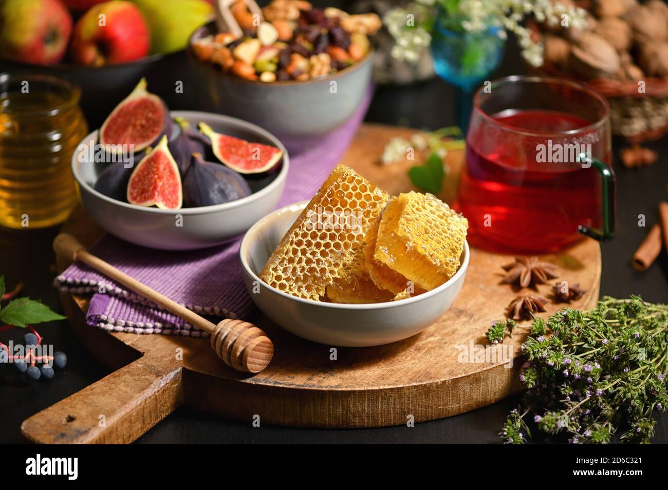 Miel, nid d'abeilles, thé, fruits secs et figues sur la table d'automne Banque D'Images