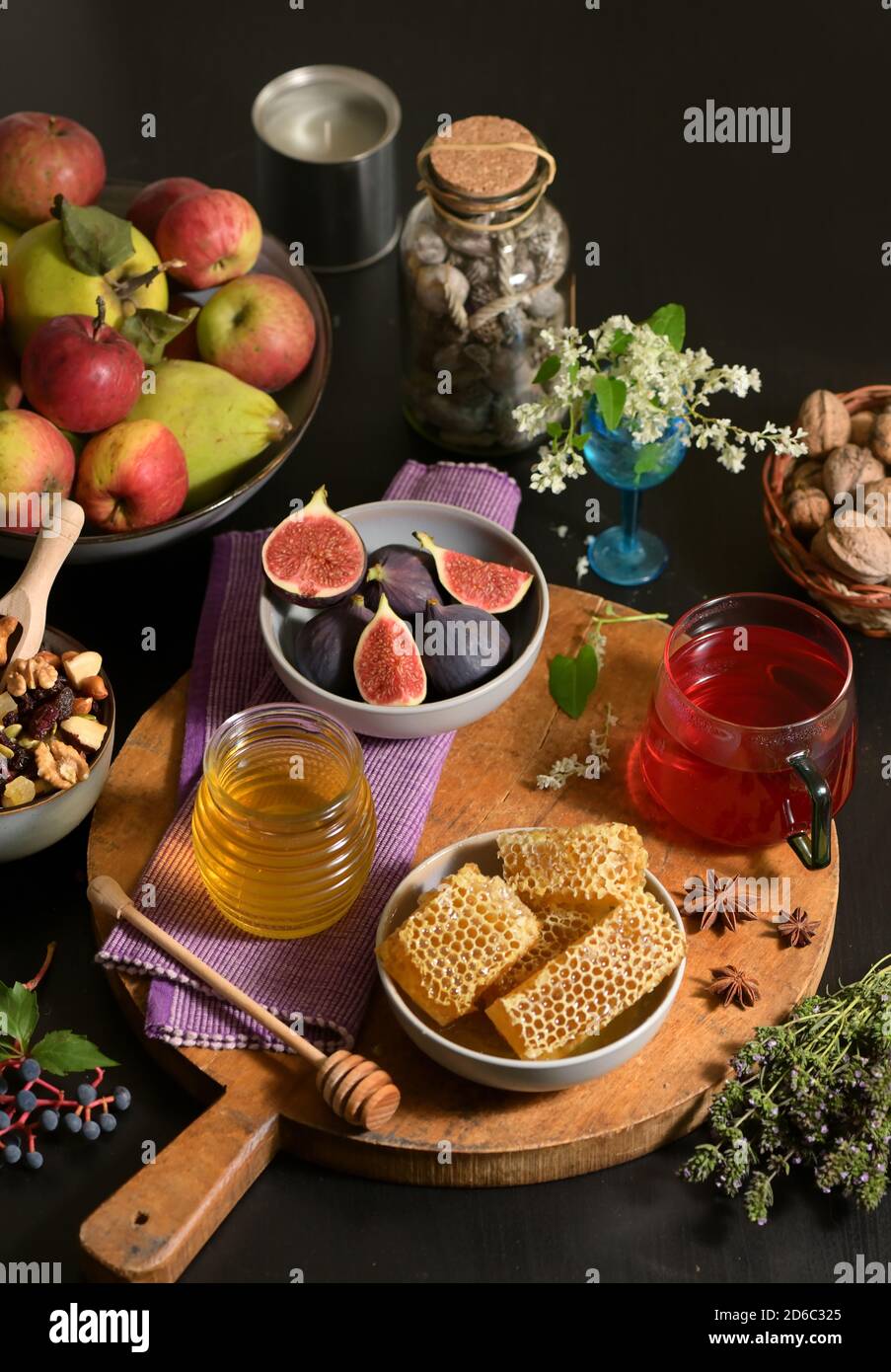 Miel, nid d'abeilles, thé, fruits secs et figues sur la table d'automne Banque D'Images