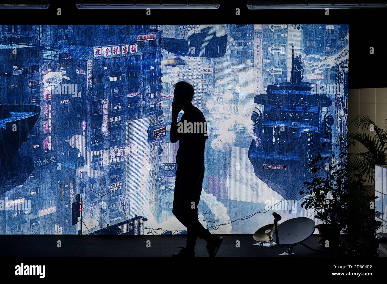 Hong Kong, Chine. 15 octobre 2020. Un homme passe devant un paysage urbain futuriste dans le cadre de l'exposition Cyberpunk à Hong Kong.Cyberpunk expositions de l'inspiration du cyber-style de vie futuriste robot thème, De même que le film hollywoodien « Blade Runner » et « Ghost in the Shell », et traite de sujets tels que la crise climatique qui s'entrelace avec l'intelligence artificielle, les machines, l'acier et la chair, la réalité et l'illusion, le passé et l'avenir. Crédit : SOPA Images Limited/Alamy Live News Banque D'Images