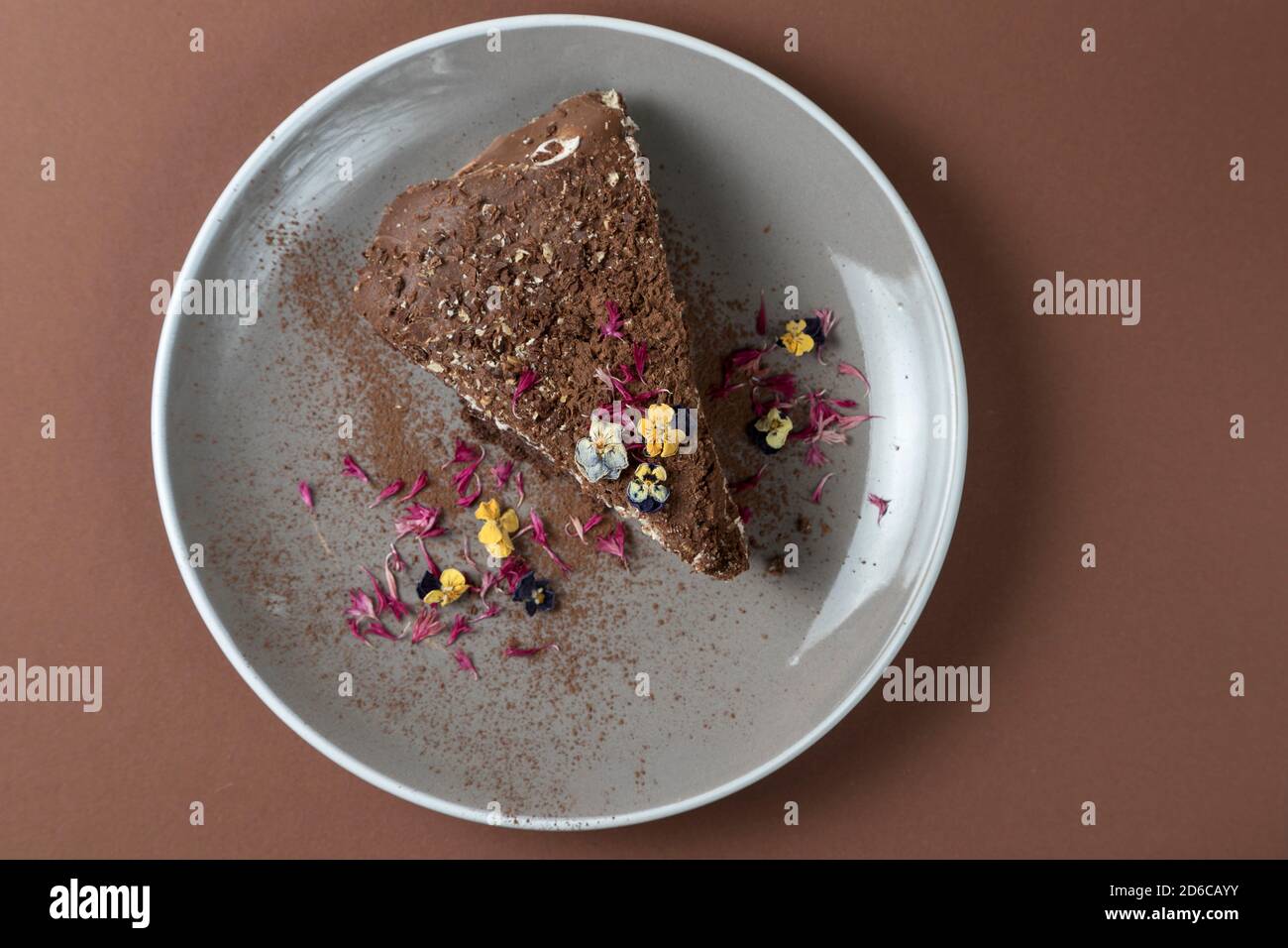 Vue de dessus d'un morceau de gâteau au chocolat avec des fleurs comestibles. Vue douce Banque D'Images