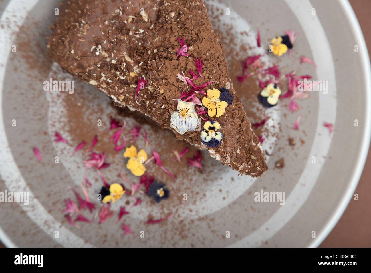 Vue de dessus d'un morceau de gâteau au chocolat avec des fleurs comestibles. Vue douce Banque D'Images