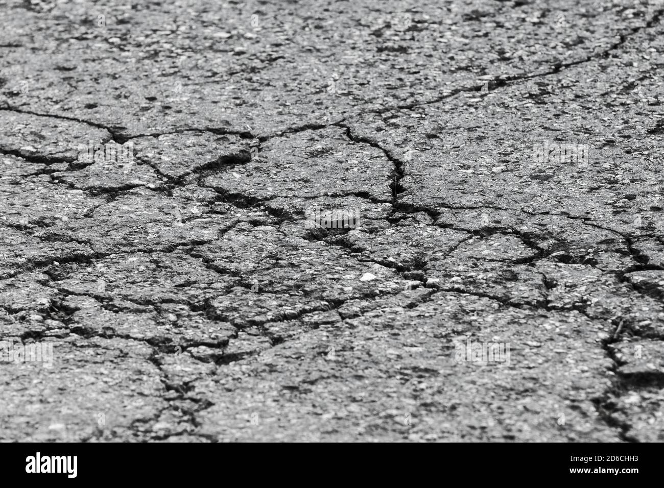 Surface de la route asphaltée endommagée. Tarmac avec fissures, gros plan. Texture de la photo d'arrière-plan de transport Banque D'Images