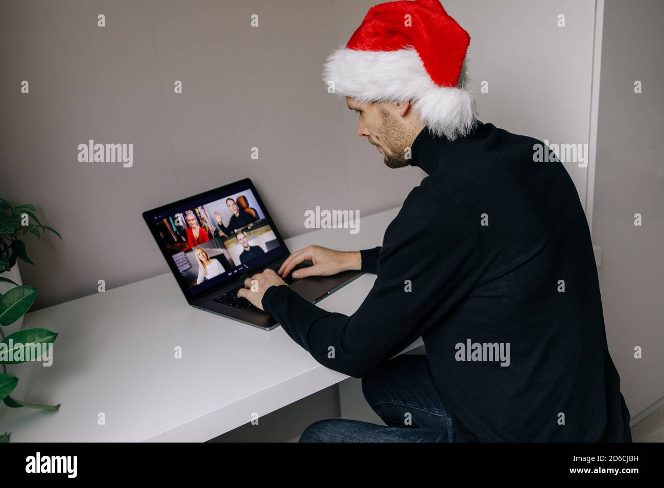 Visioconférence d'entreprise. Jeune homme ayant des appels vidéo par ordinateur dans le bureau à domicile. Fête de Noël virtuelle. Réunion d'équipe en ligne à distance Banque D'Images