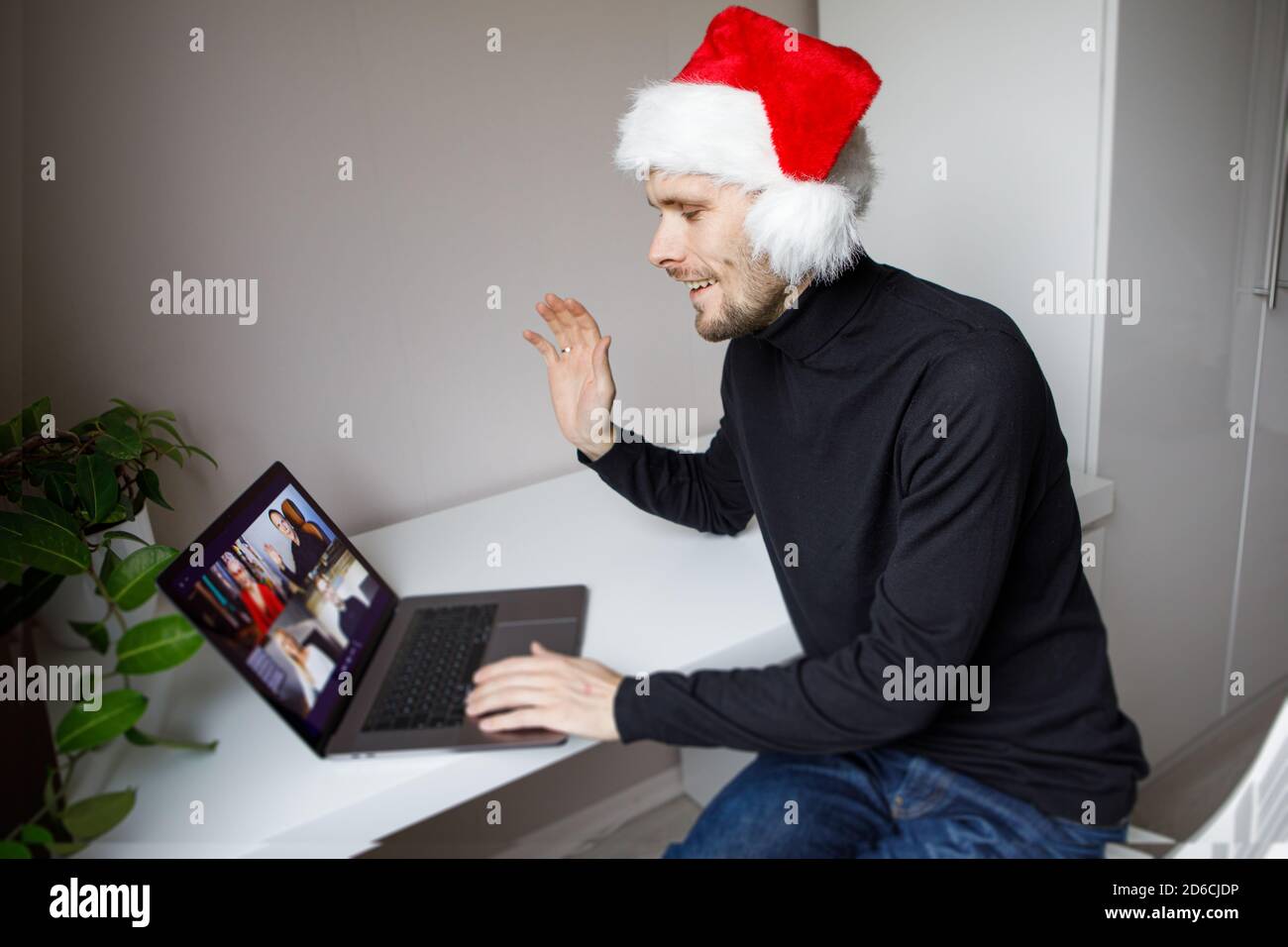 Visioconférence d'entreprise. Jeune homme ayant des appels vidéo par ordinateur dans le bureau à domicile. Fête de Noël virtuelle. Réunion d'équipe en ligne à distance Banque D'Images