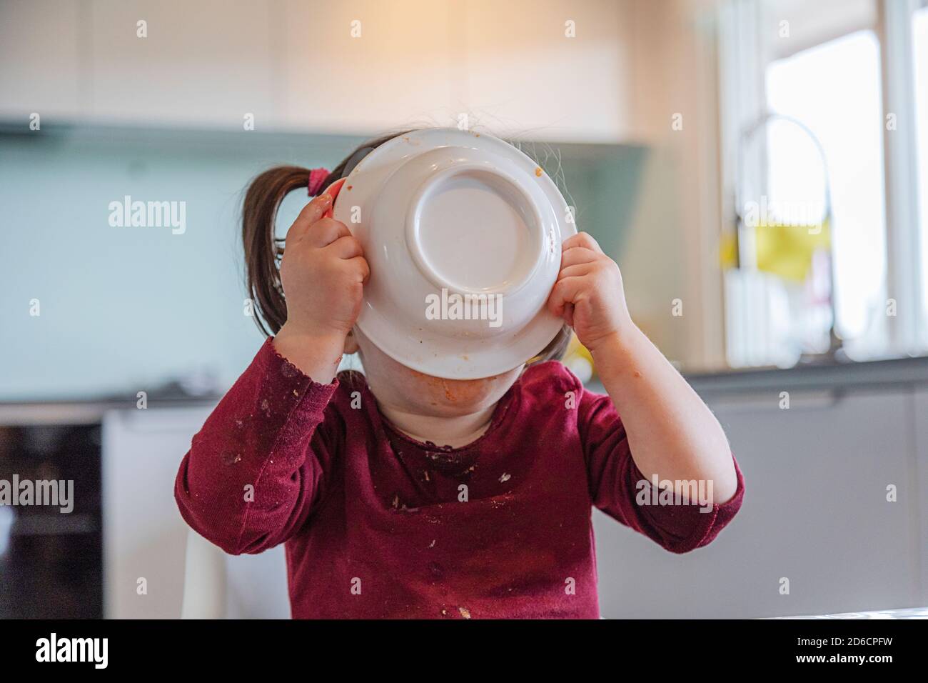 Girl eating at table Banque D'Images