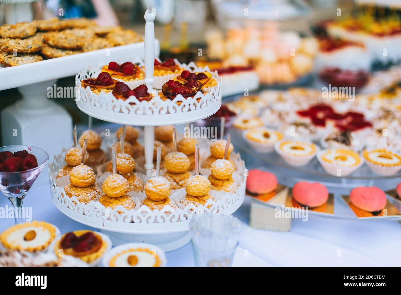Bar à bonbons pour mariages avec petits gâteaux aux couleurs vives différentes, macarons, gâteaux, gelée et fruits. Banque D'Images