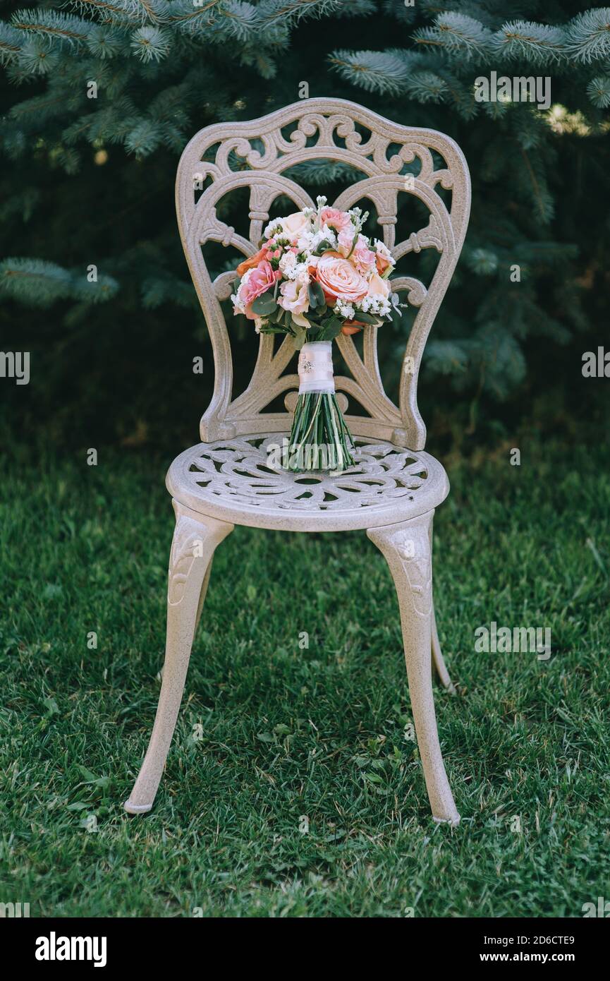 Beau bouquet élégant de la mariée en rose sur une chaise à l'extérieur dans le jardin. Banque D'Images