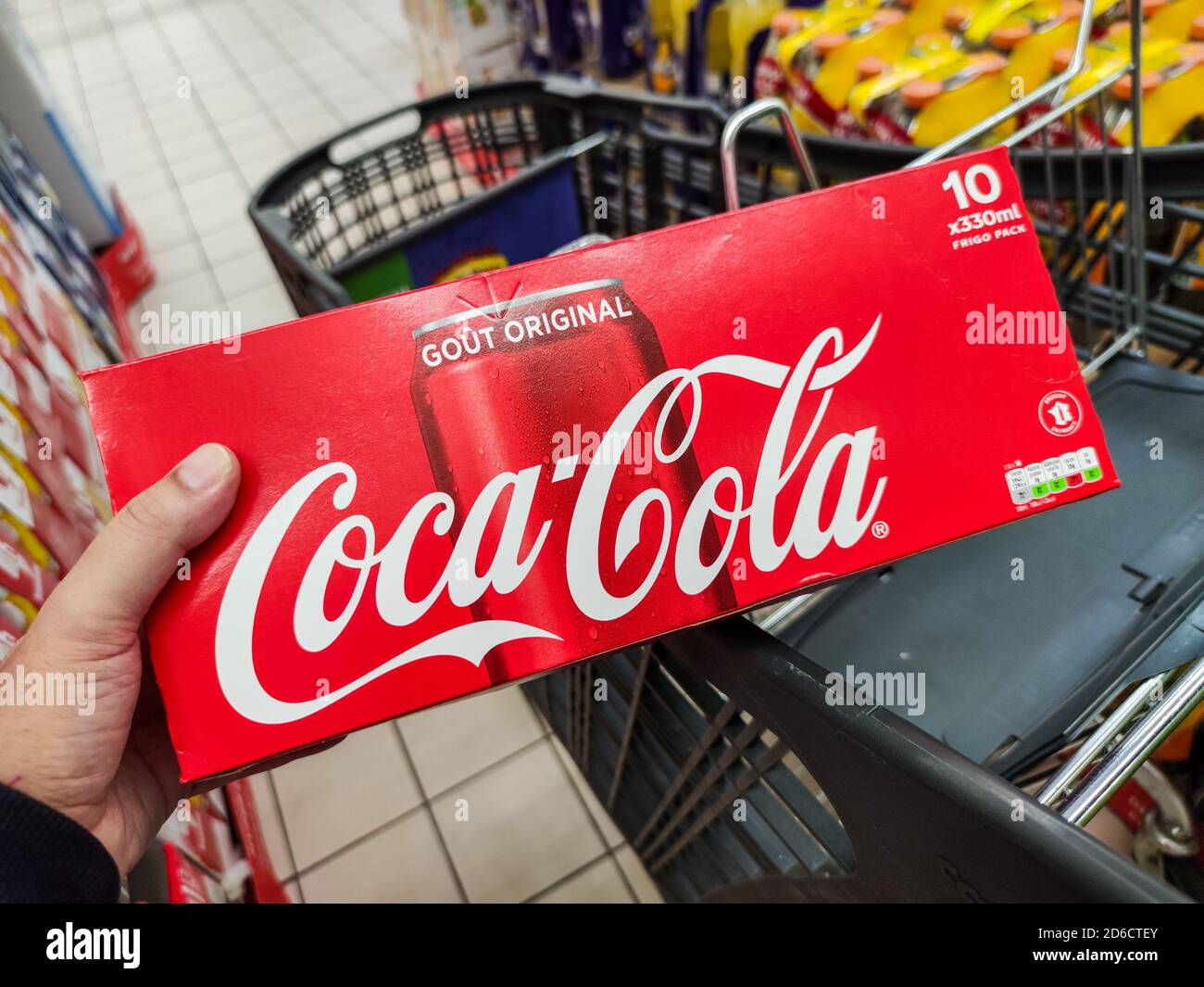 Puilboreau, France - 14 octobre 2020:gros plan de l'homme à la main achetant la boisson gazeuse Coca Cola et plaçant un paquet de coca cola dans son panier de supermarché Banque D'Images