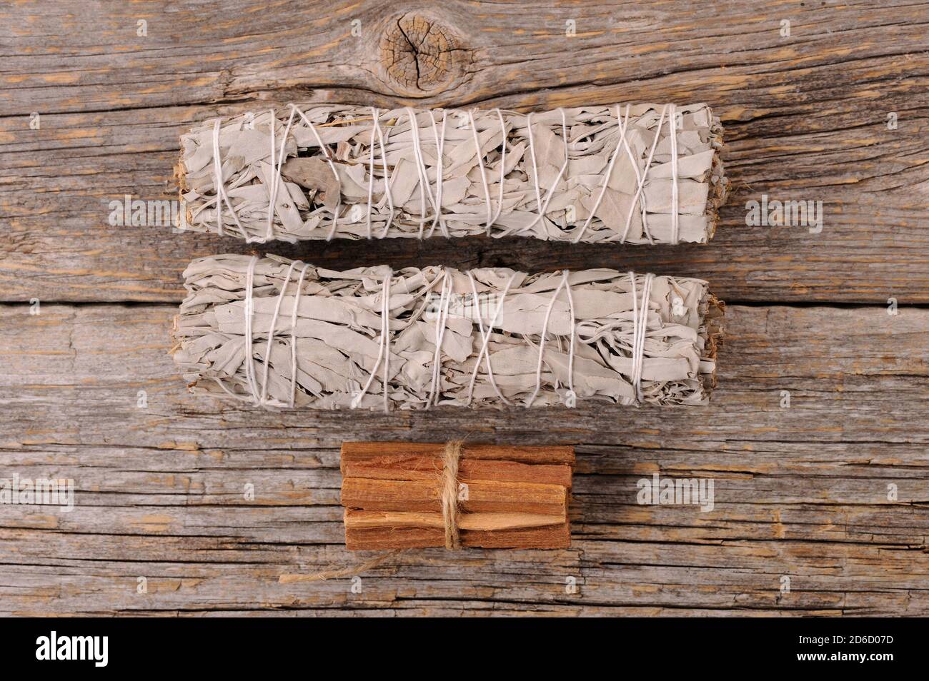 Bandles à sauge blanche séchée et bâtonnets de palo santo sur fond de bois ancien. Suppression et correction de l'énergie.gros plan avec de l'espace pour le texte. Banque D'Images