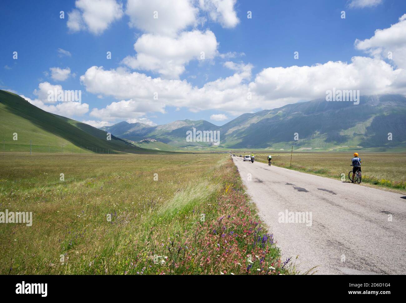 La route pavée qui traverse Pian Grande près de Castelluccio bondit de touristes sur les vélos, motos et voitures Banque D'Images