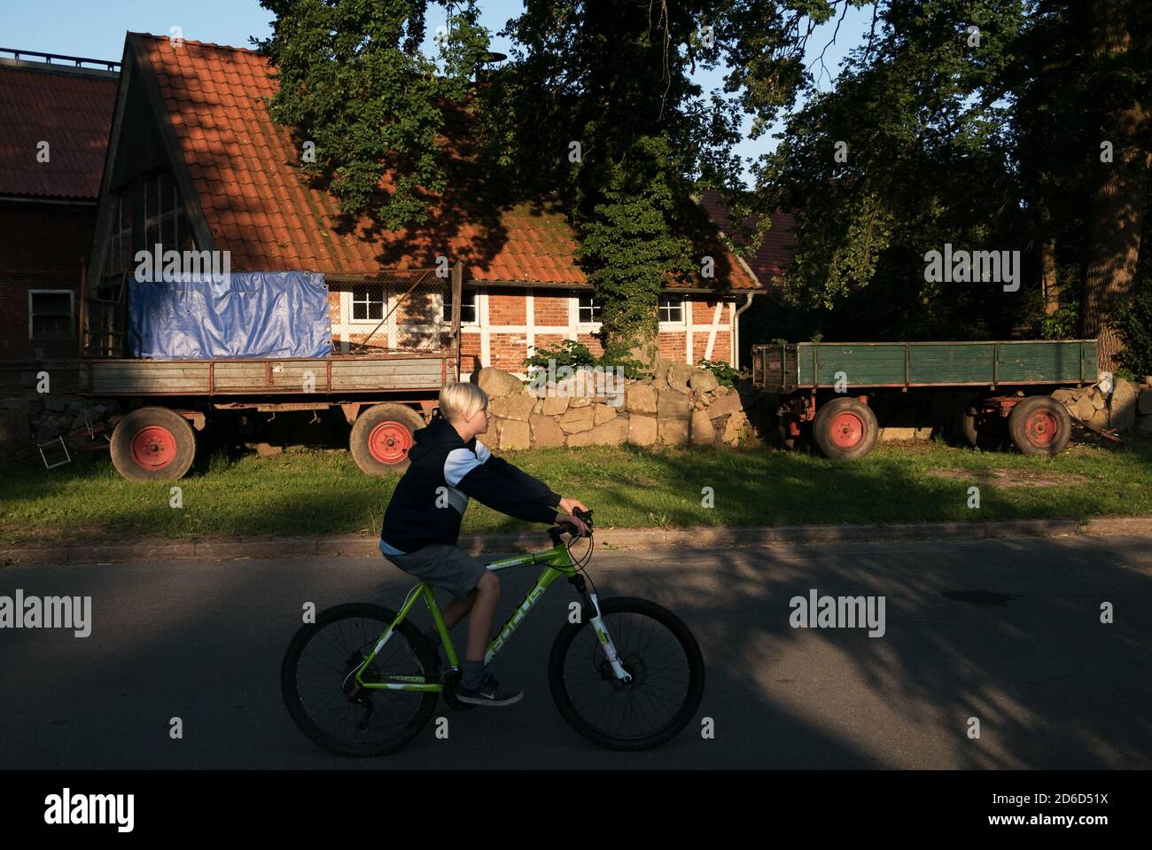 19.07.2018, Heidenau, Basse-Saxe, Allemagne - Boy sur un vélo sur Dorfstrasse. 00A180719D003CAROEX.JPG [AUTORISATION DU MODÈLE : NON, AUTORISATION DU PROPRIÉTAIRE : NON (C) CA Banque D'Images