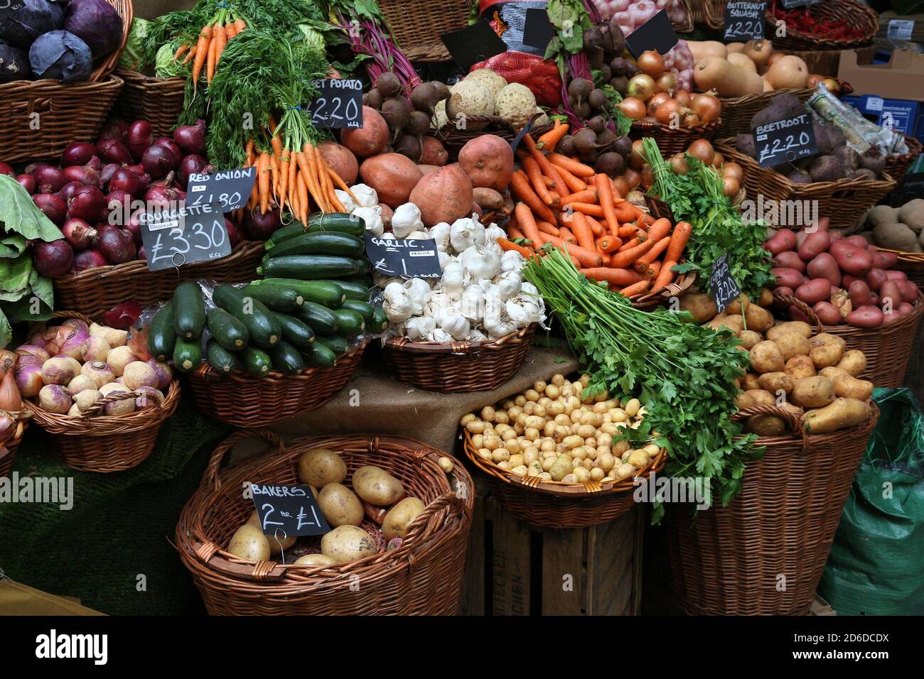 Marché borough de Londres - les prix de la pomme de terre, de la courgette, de la carrt et de l'oignon dans une stalle du marché. Banque D'Images