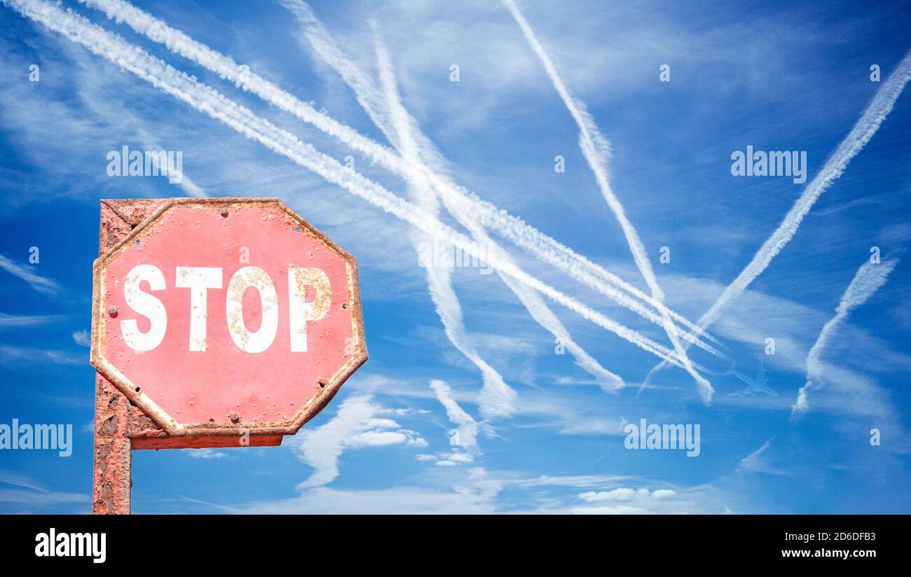 L'avion s'oppose au ciel bleu avec un panneau stop au premier plan. Réchauffement climatique, pollution de l'air..., concept. Banque D'Images