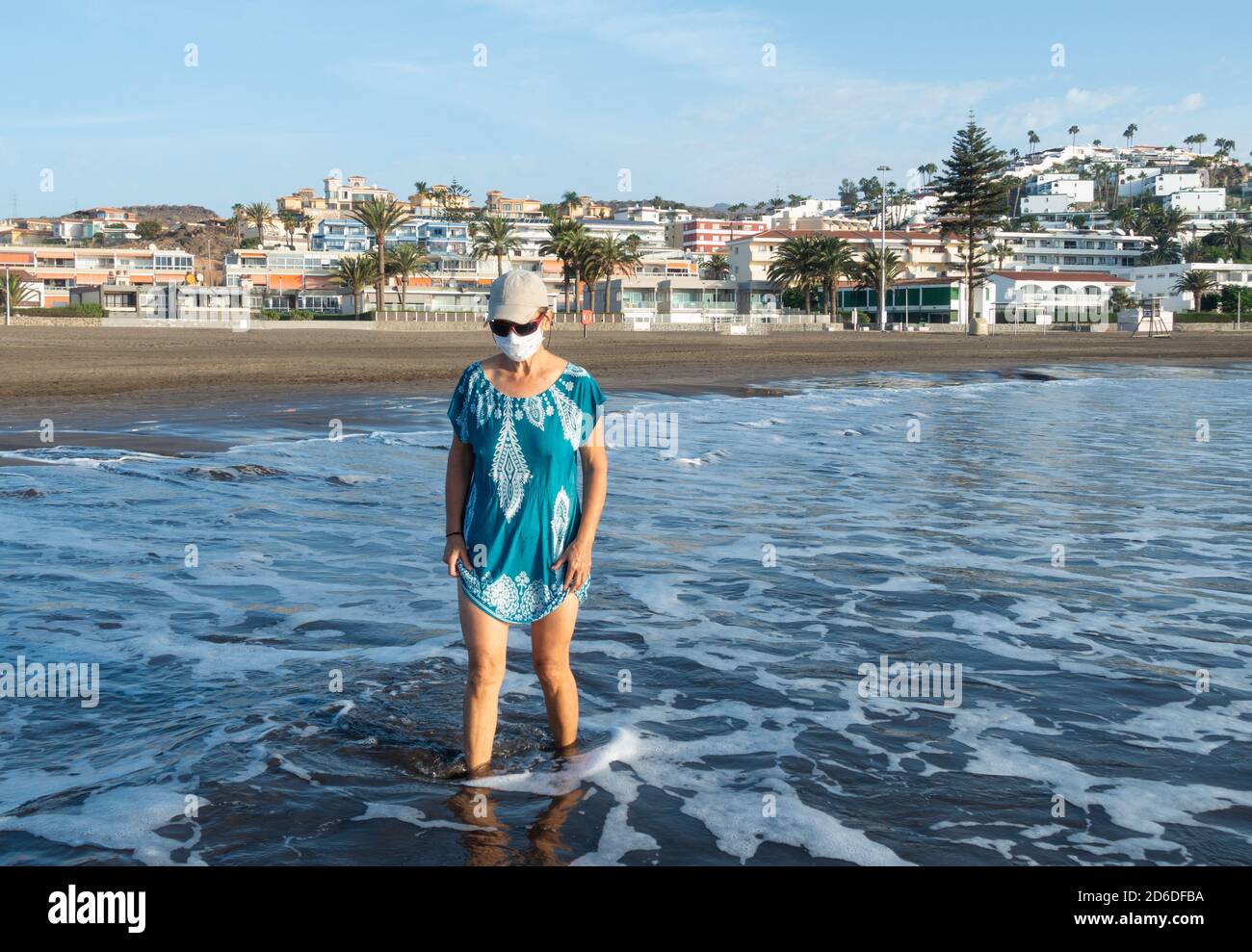 Femme portant un visage couvrant la marche sur la plage à San Agustin, Gran Canaria, îles Canaries, Espagne Banque D'Images