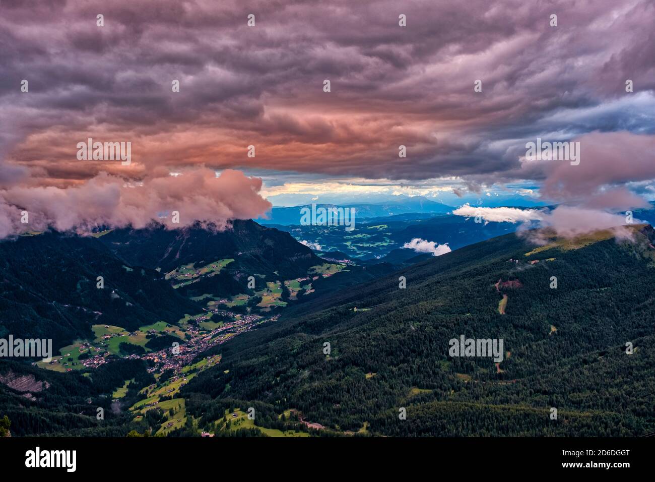 Vue aérienne sur Ortisei, Saint-Ulrich, depuis la station de téléphérique Seceda, nuages sombres illuminés par le coucher du soleil Banque D'Images