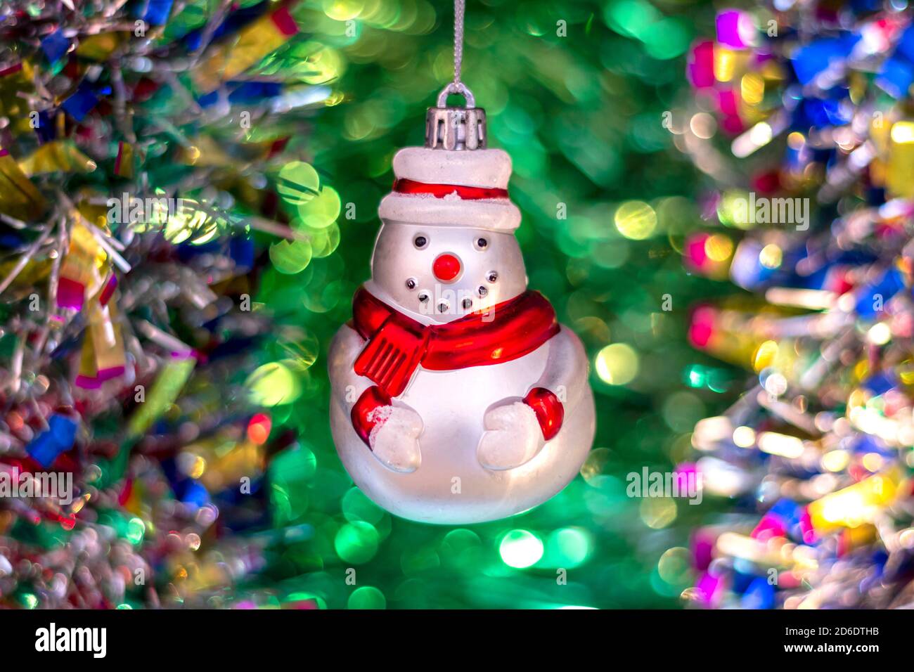 Jouet soviétique du nouvel an en verre vintage (bonhomme de neige) sur le  fond d'un arbre de Noël et d'une guirlande lumineuse colorée Photo Stock -  Alamy