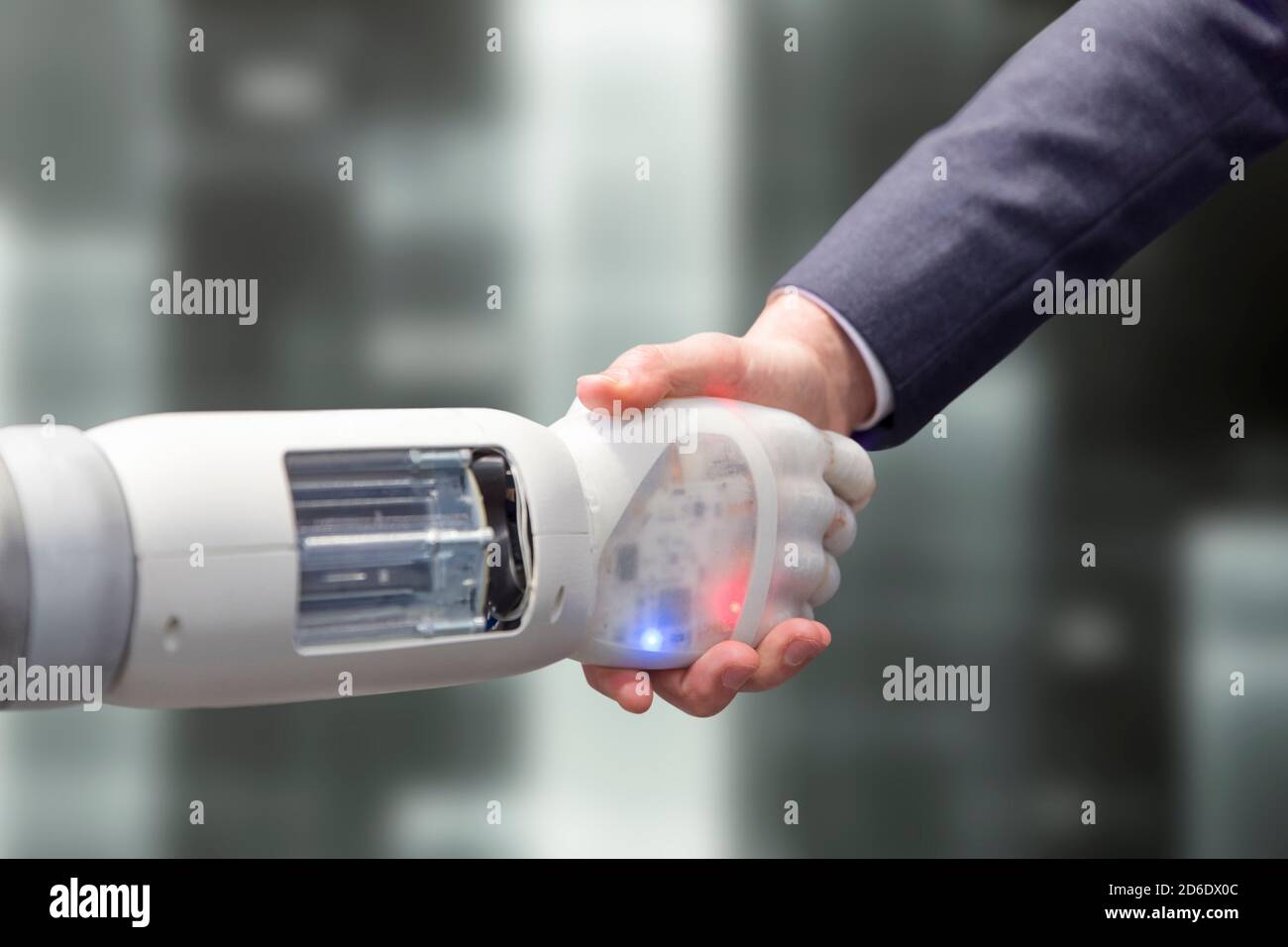Le robot secoue les mains avec un homme Banque D'Images