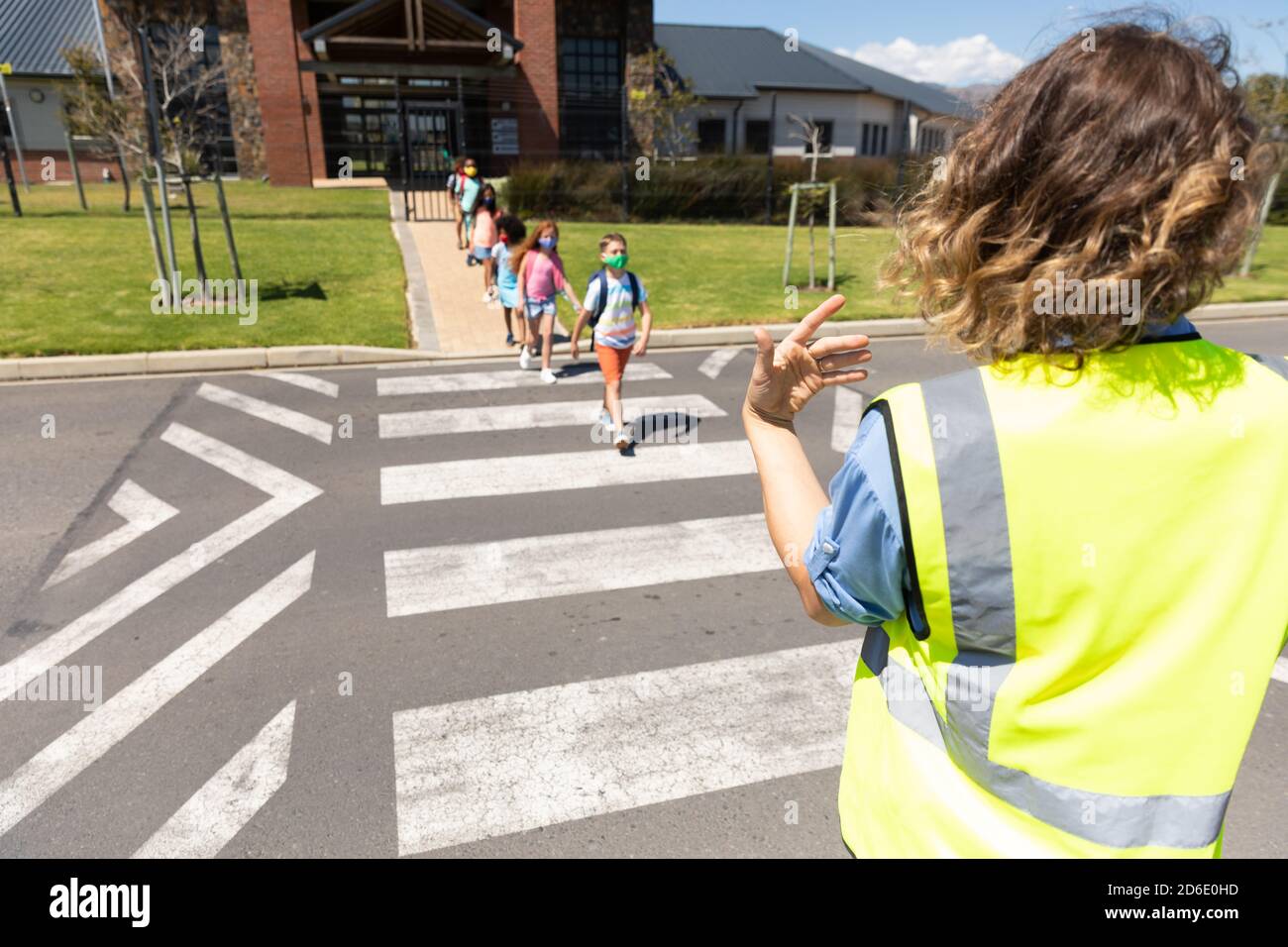 Groupe d'enfants portant des masques de visage traversant la route Banque D'Images