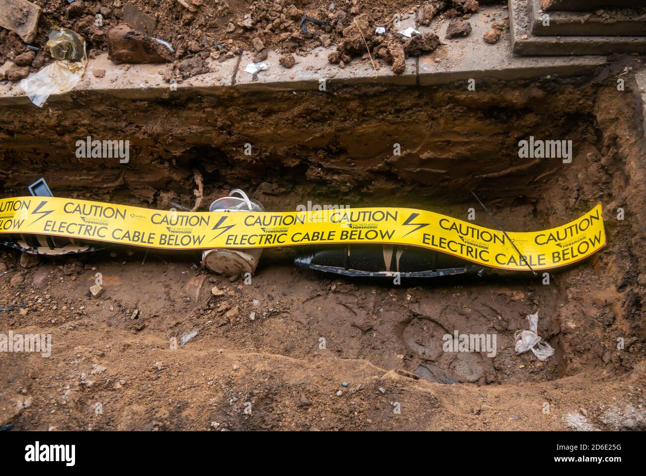 Excavation pour exposer un câble d'alimentation électrique récemment réparé avec un ruban d'avertissement sur le câble afin d'éviter tout dommage lors d'une excavation ultérieure. Banque D'Images