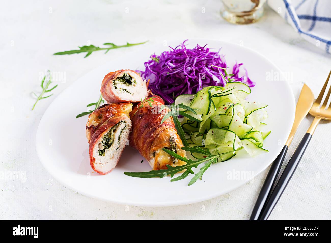 Régime cétogène. Plat de dîner avec rouleau de viande de poulet Wish bacon et salade que le chou rouge, concombre, arugula. Détox et concept sain. Nourriture de keto. Banque D'Images