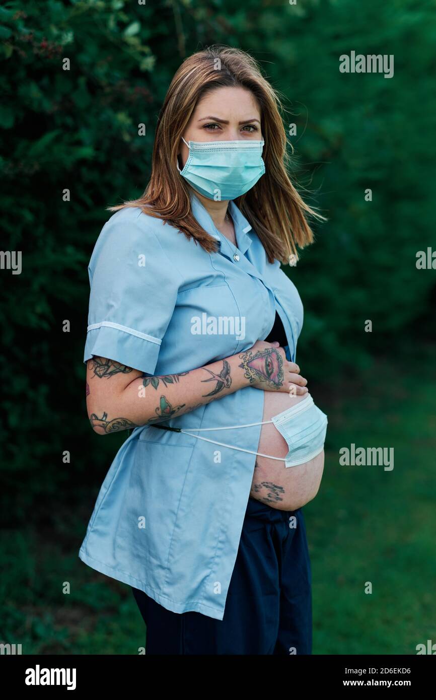 Travailleur de soins aux femmes enceintes préoccupé par l'avenir tout en travaillant tout au long de la pandémie du coronavirus Covid 19 2020. Banque D'Images