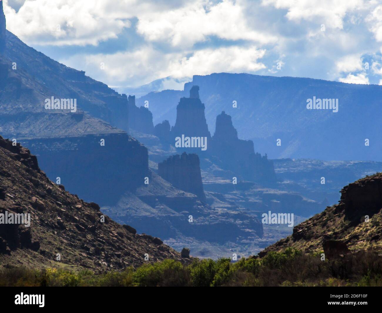 Les Fisher Towers, au loin avec seulement les silhouttes bleues visibles, comme vu juste à l'entrée de Castle Valley, à Moab, USA Banque D'Images