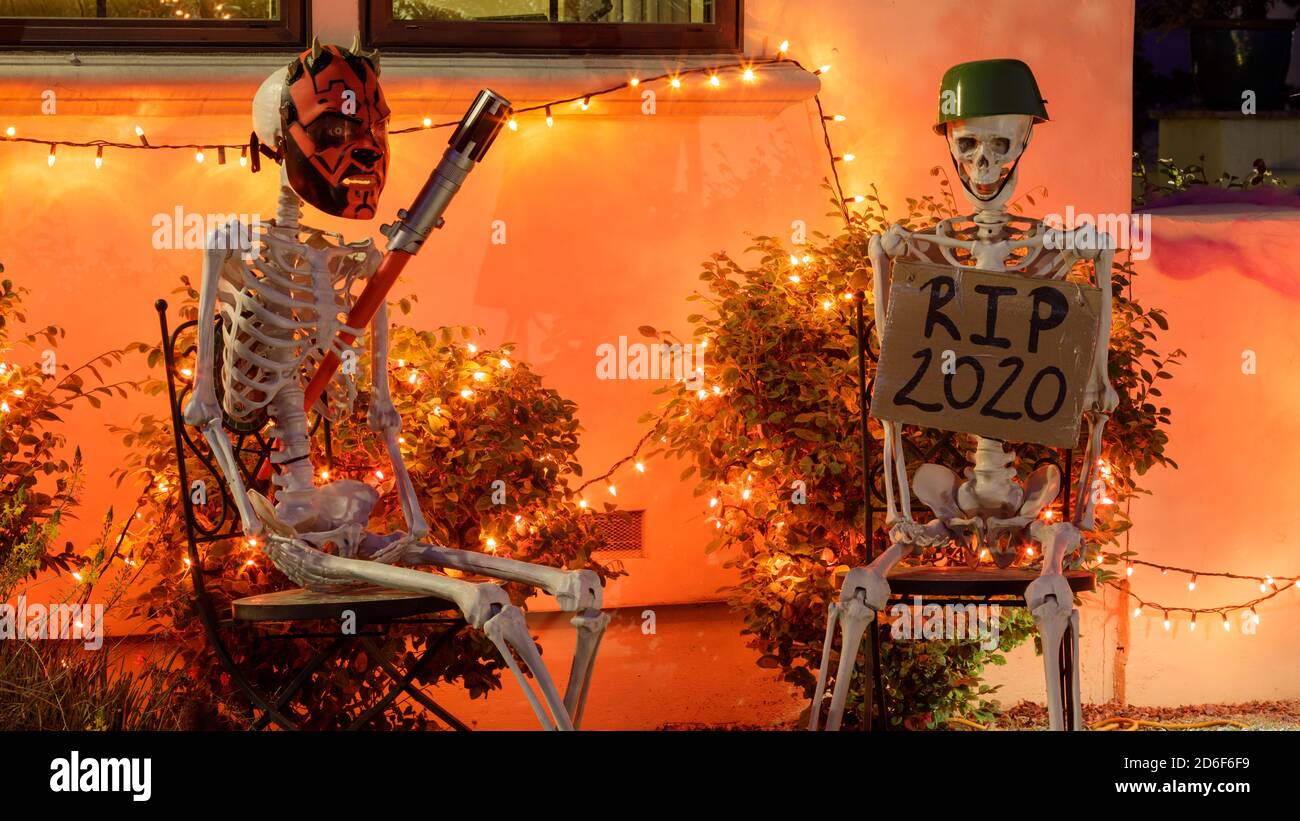 Deux squelettes assis sur des chaises à l'extérieur d'une maison pour Halloween Banque D'Images