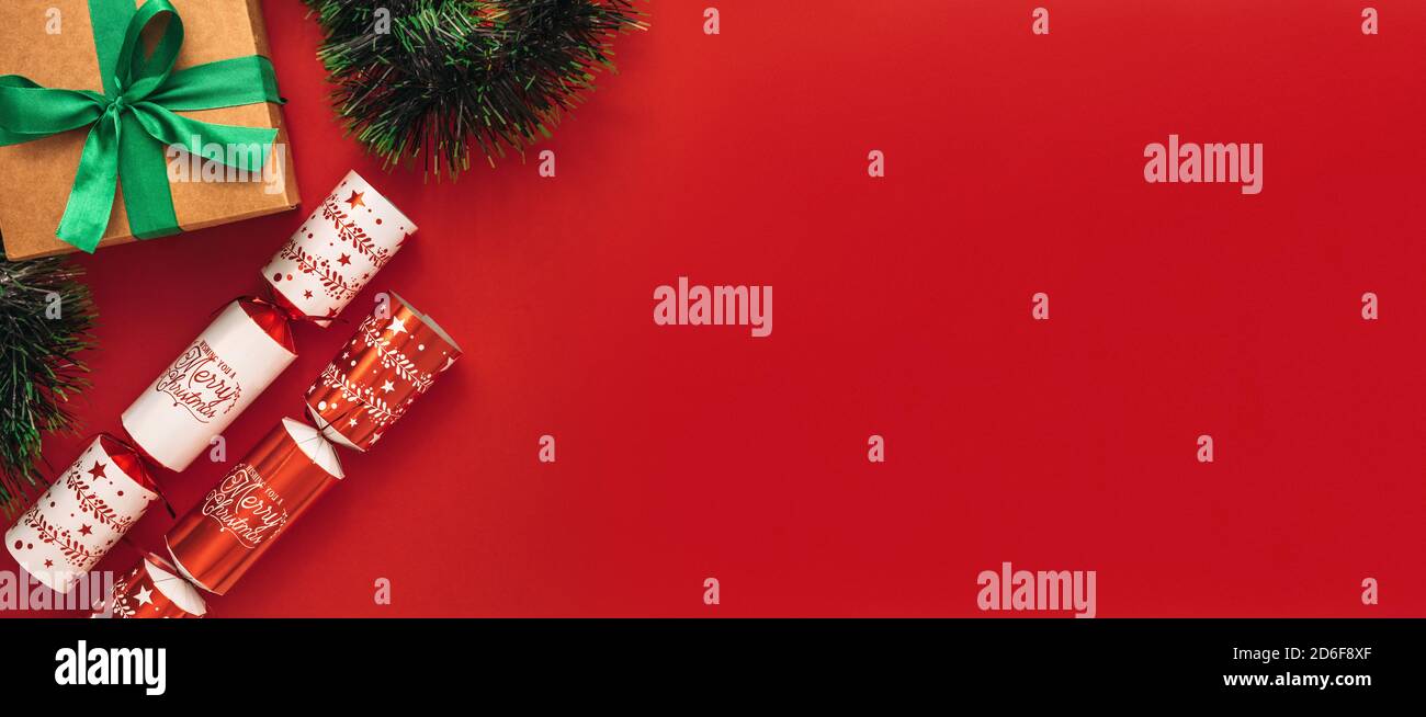 Belle flay laïcs de cloches de Noël avec boîte cadeau et garland sur fond rouge. Mise à plat de Noël design avec copie espace. Banque D'Images