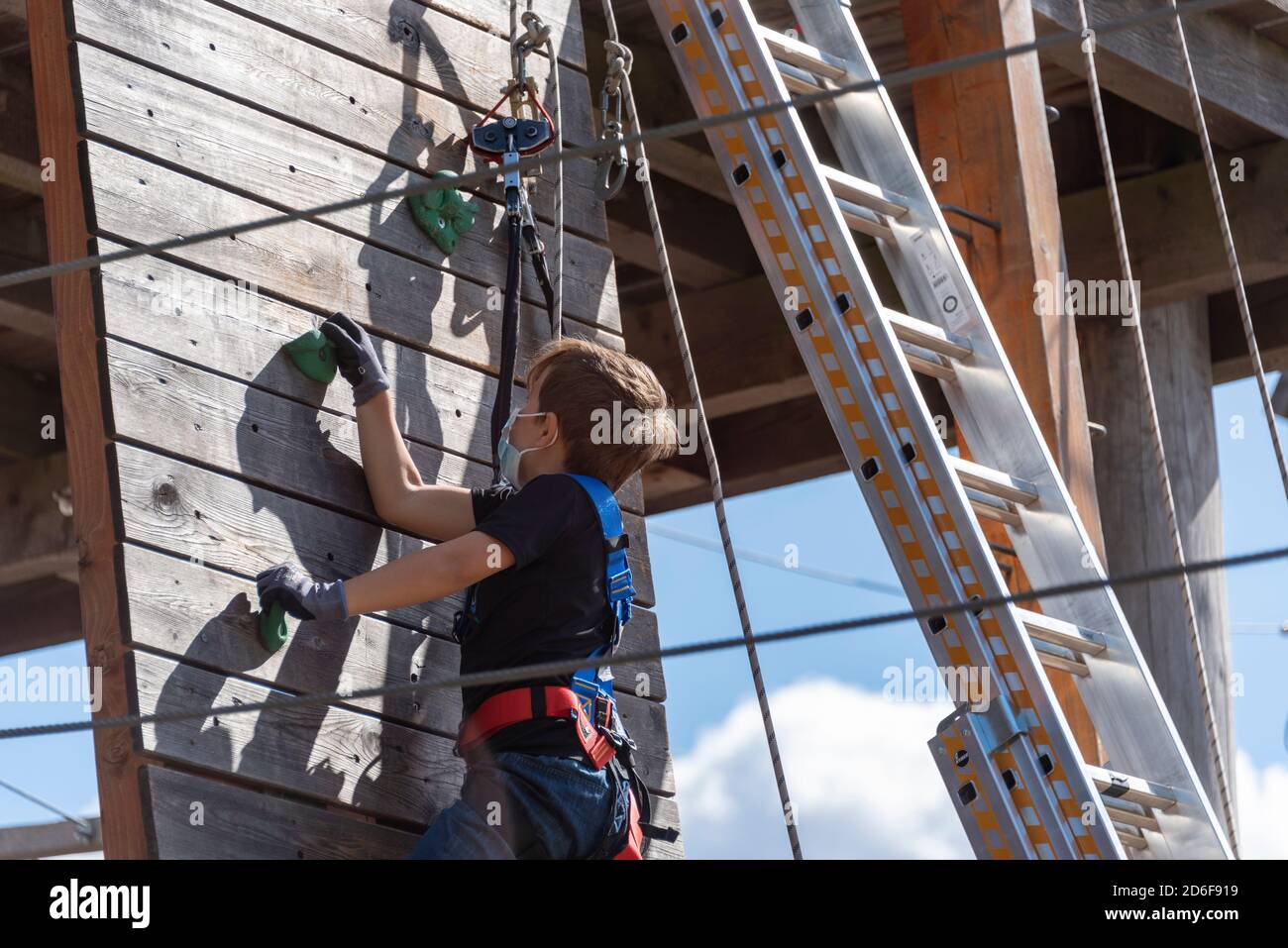 Garçon, 9 ans, monte dans un parc d'escalade Banque D'Images