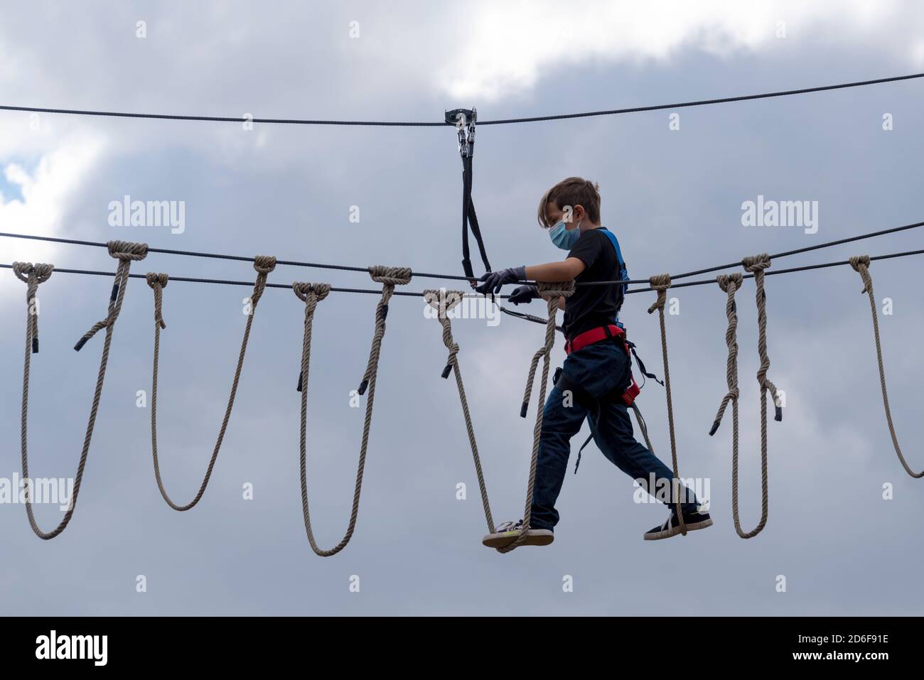 Garçon, 9 ans, monte dans un parc d'escalade Banque D'Images