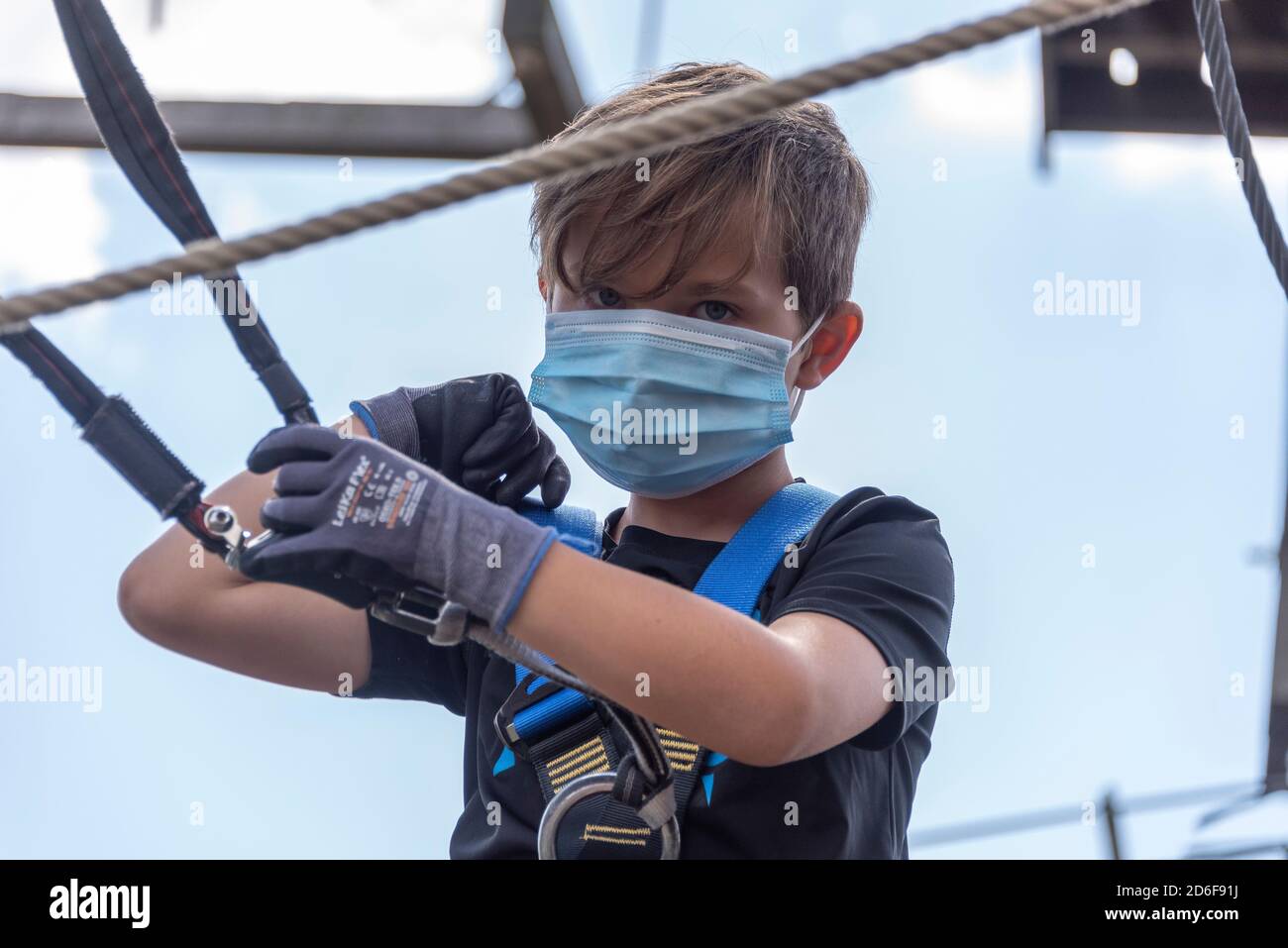 Garçon, 9 ans, monte dans un parc d'escalade Banque D'Images