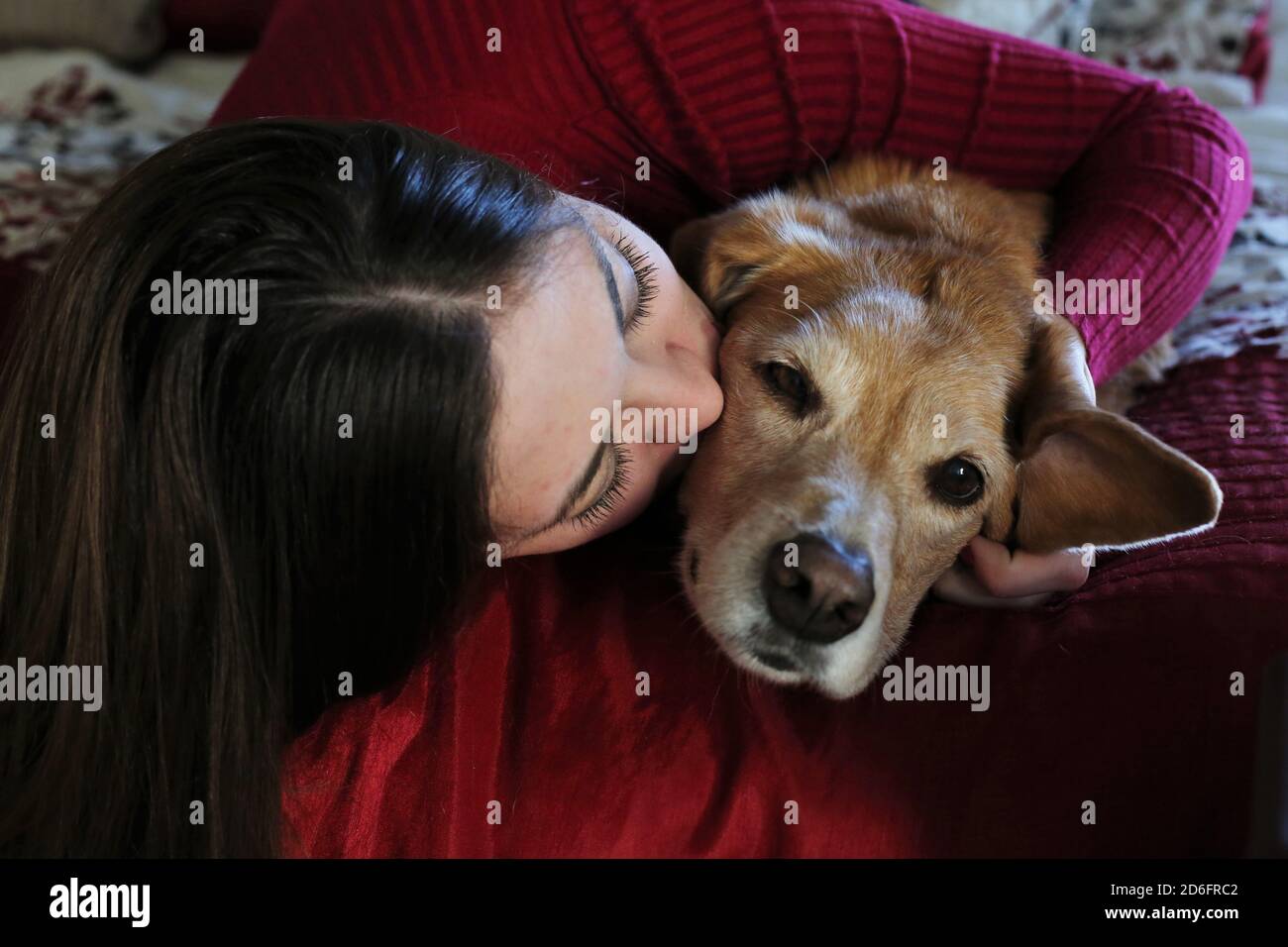 Une jeune femme embrassant un vieux chien. Banque D'Images