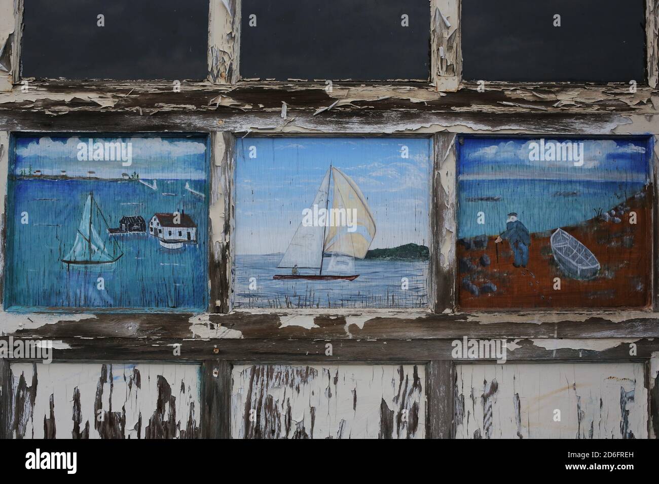 Pêche et voile scènes peintes sur une vieille porte de garage, à Grand Marais, Minnesota. Banque D'Images