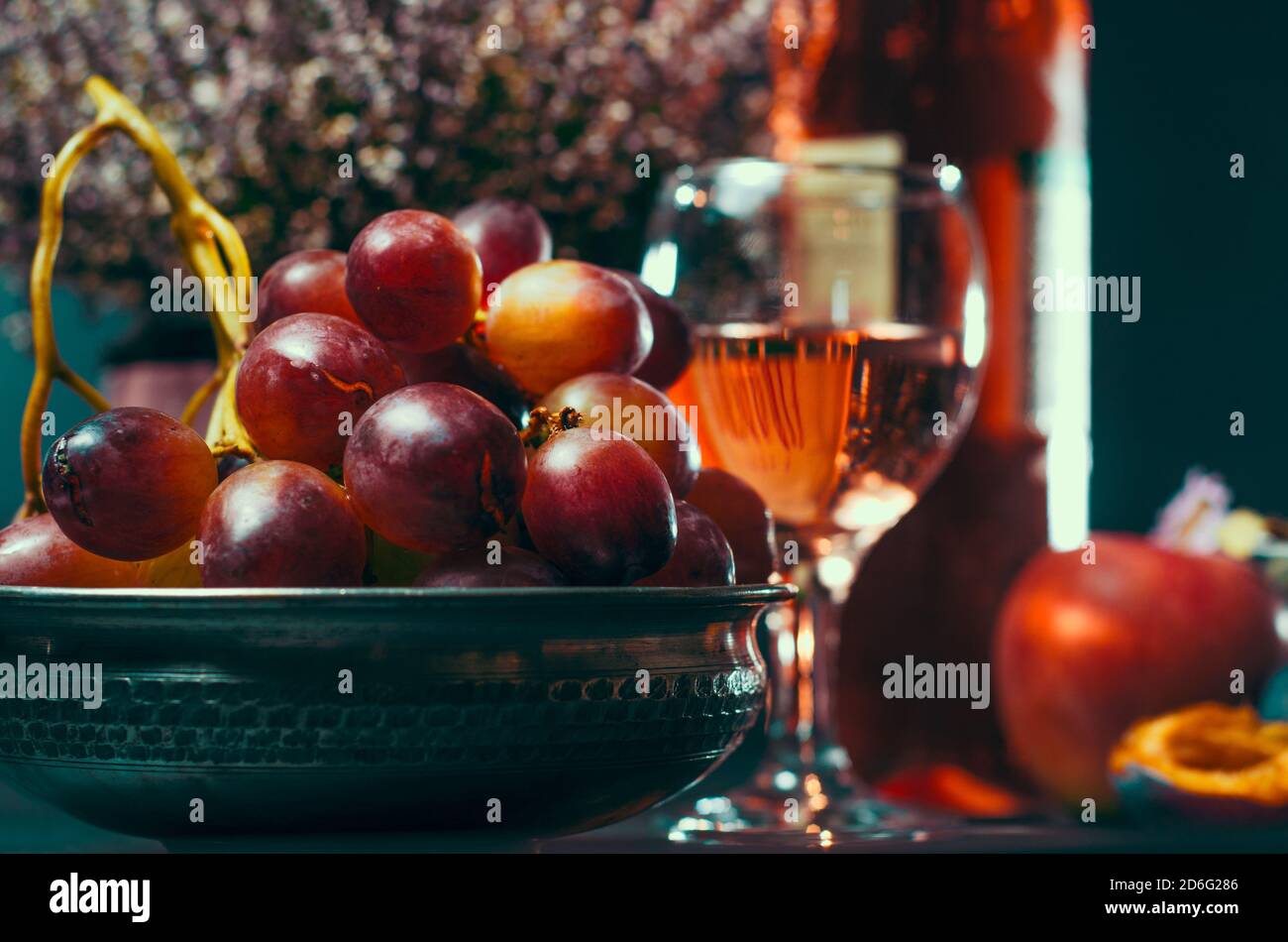 reste la vie de raisins mûrs avec pomme et prunes sur le fond d'un verre de vin Banque D'Images