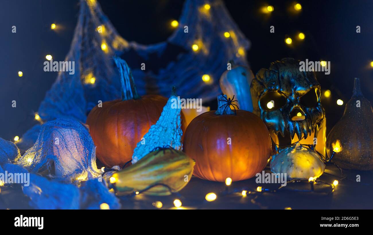 Halloween citrouille dans un paysage effrayant d'automne la nuit. Citrouilles, masque effrayant, lumières, araignées et toile d'araignée. Banque D'Images