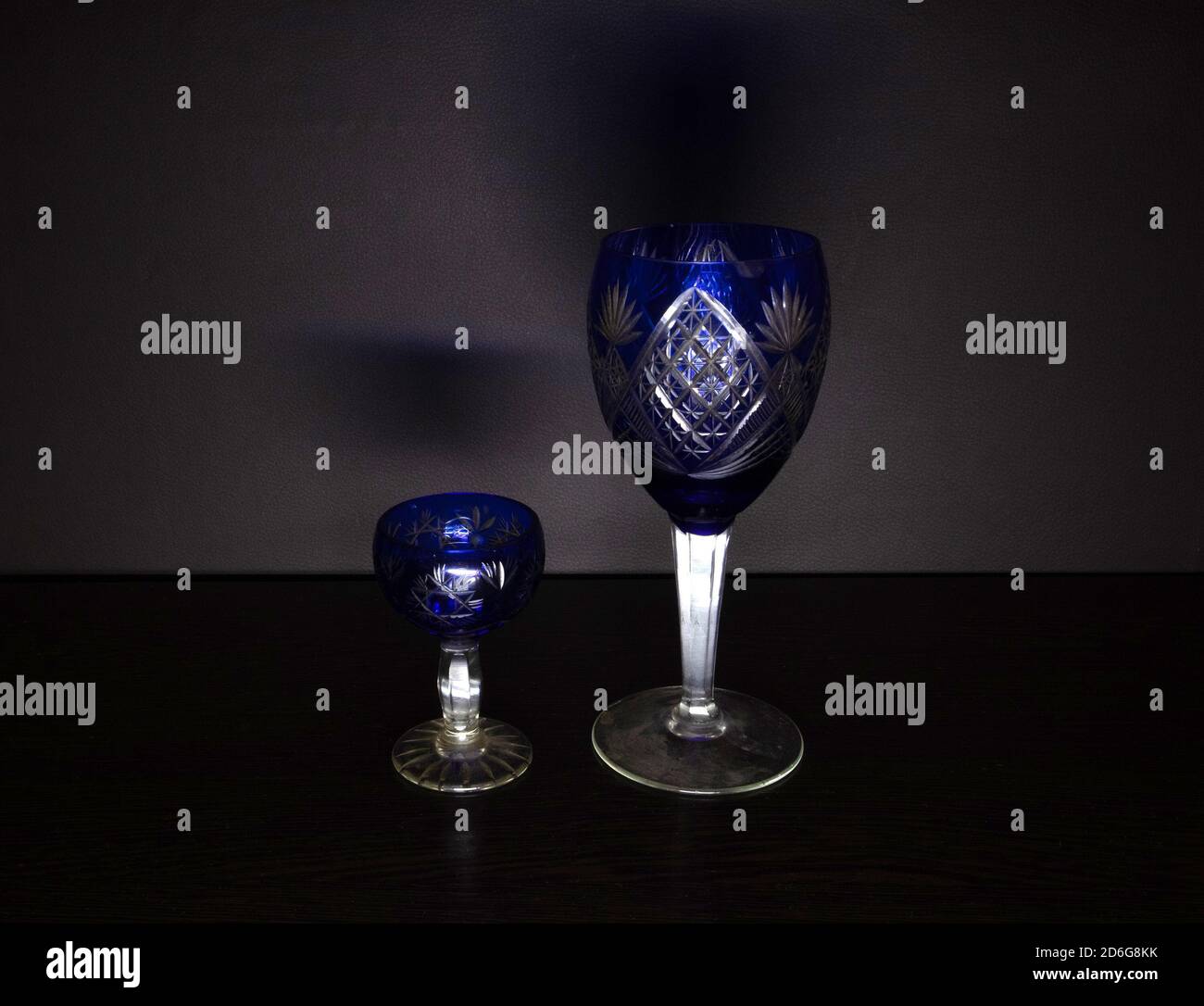 Deux gobelets de vin vintage en verre bleu dans une obscurité minimaliste arrière-plan Banque D'Images