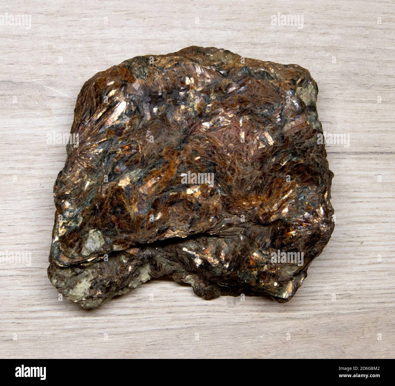 Grand morceau de feldspath minéral brillant à facettes allongé sur un surface en bois Banque D'Images