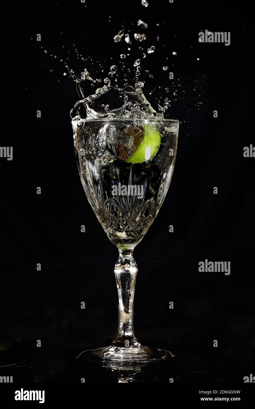 Wineglass avec splash et lime. Banque D'Images