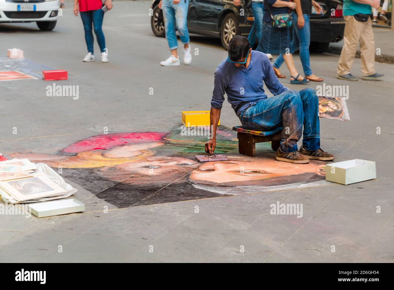 Vue rapprochée d'un artiste de la rue à Florence, dessin avec de la craie sur l'asphalte de la célèbre Madonna della seggiola peinture de l'Italien... Banque D'Images